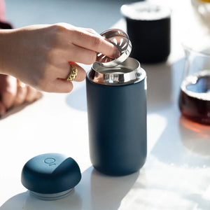 Hånd, der sætter filter i mat blå genanvendelig kaffekop, del af Take away og EspressoGear, alt om kaffe.